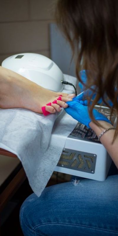 A beautician performs a pedicure on a woman's feet with precision and care.