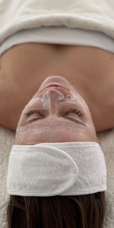 Woman enjoying a rejuvenating spa facial treatment with a calming atmosphere.